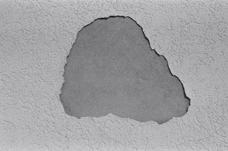 a black and white photo of a crack in a concrete wall