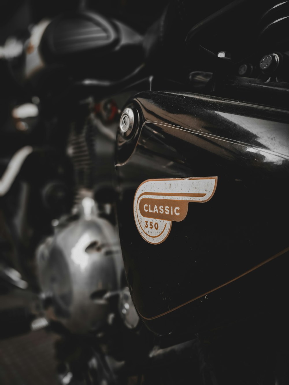 a close up of a black motorcycle with a classic sticker on it