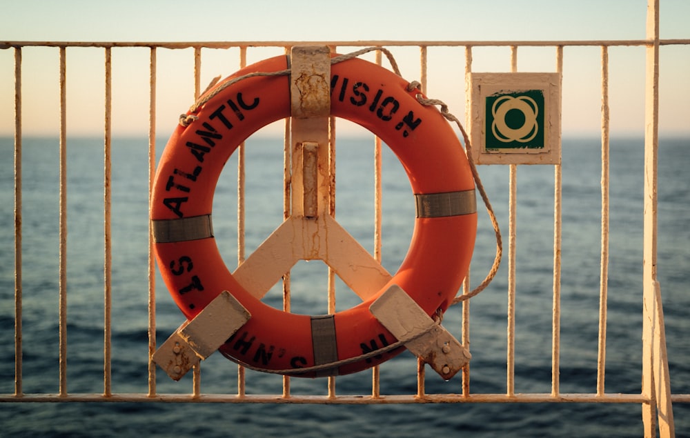a peace sign is attached to a fence near the ocean