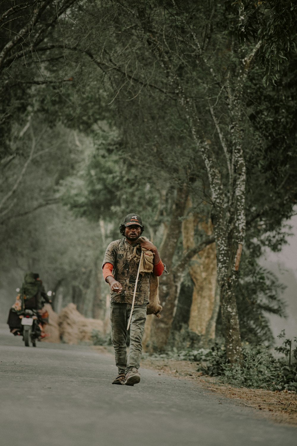 a man walking down a road with a backpack on his back