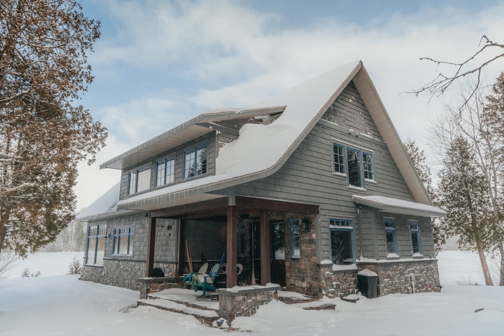 a house in the middle of a snowy field