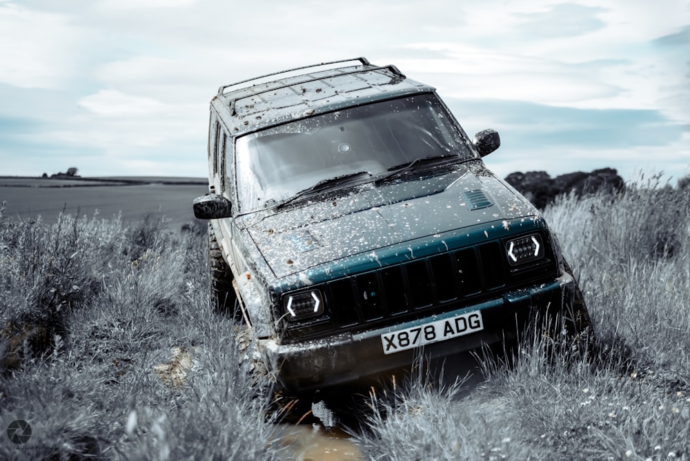 a jeep parked in a field of tall grass