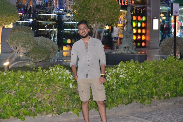 Smiling estate agent standing proudly beside a shop window featuring a vibrant LED film display.
