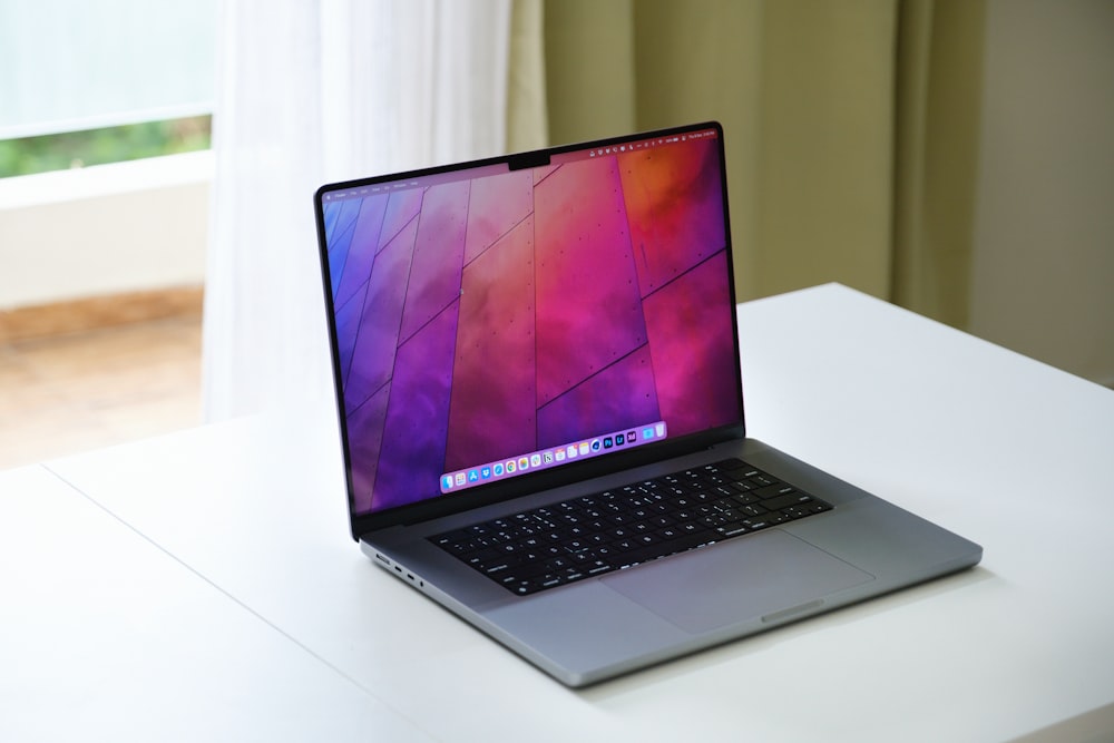 a laptop computer sitting on top of a white desk