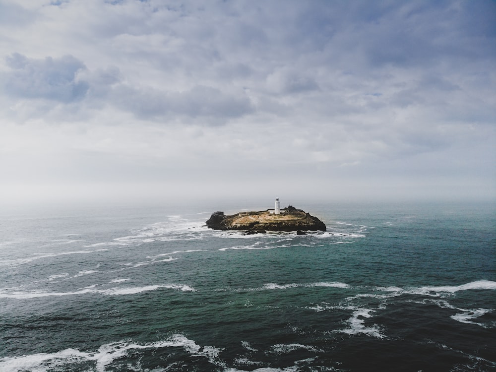 a lighthouse on an island in the middle of the ocean