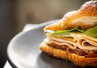 Artistic shot of a gourmet club sandwich layered with turkey, bacon, and crisp lettuce.