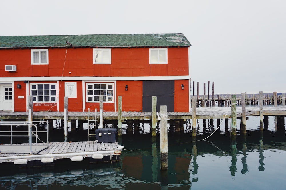 a red house sitting on top of a pier