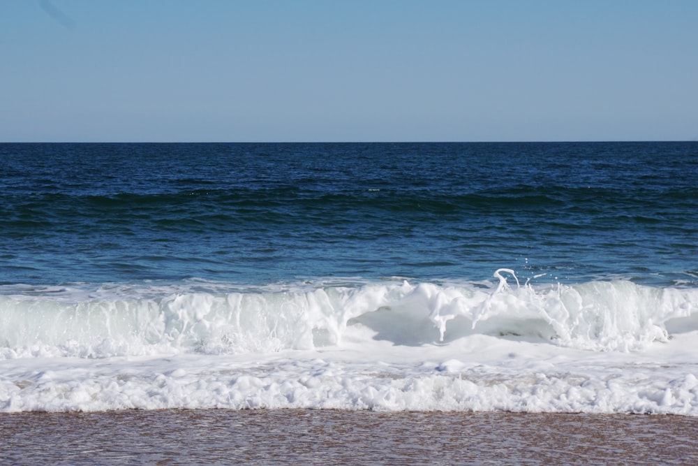 a wave is coming in to the shore of the ocean