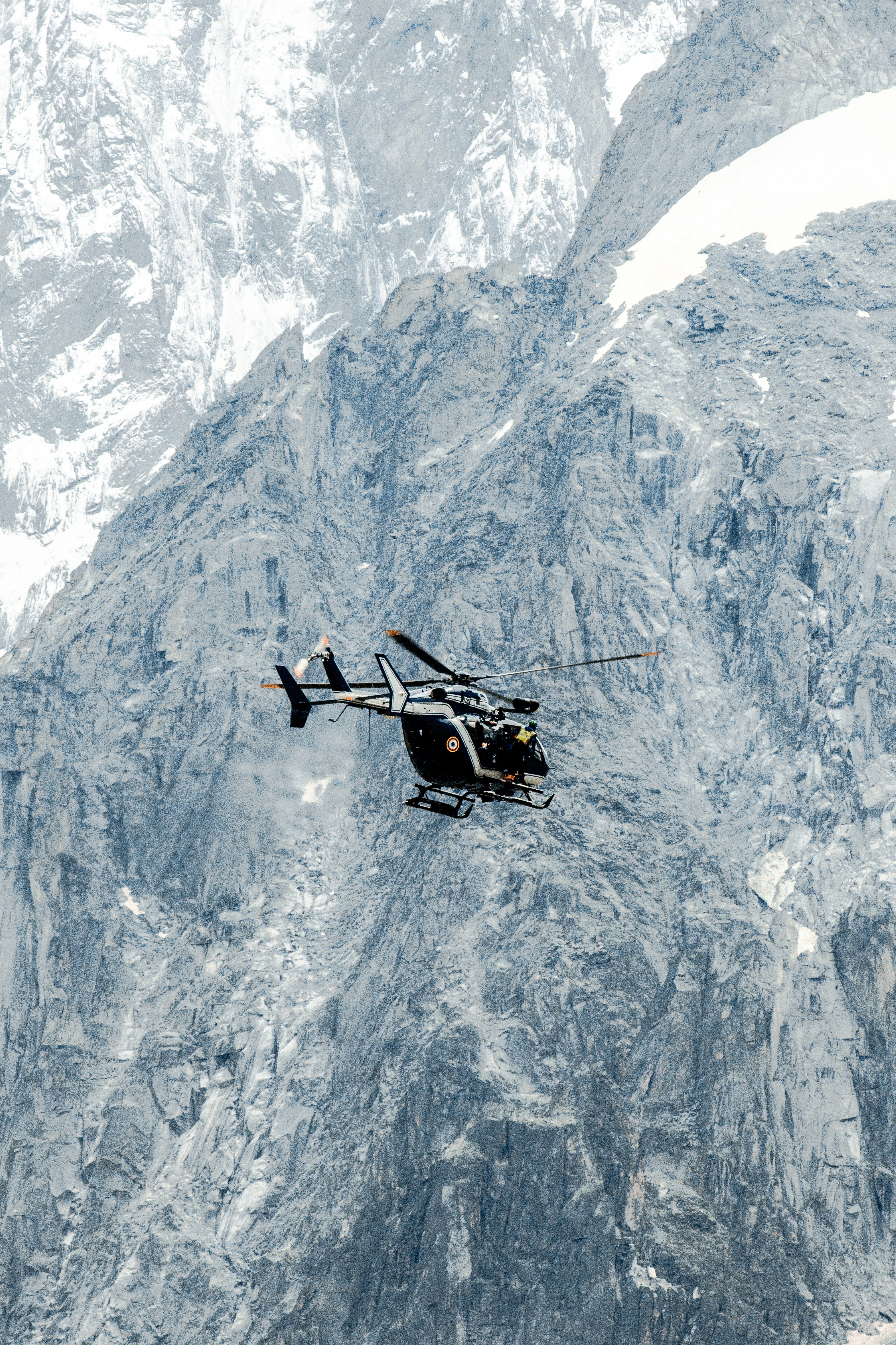 Un elicottero in bianco e nero che sorvola una montagna