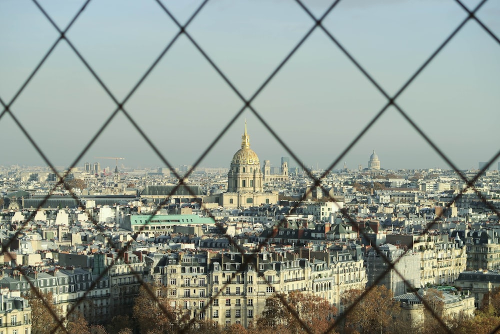 a view of a city through a chain link fence