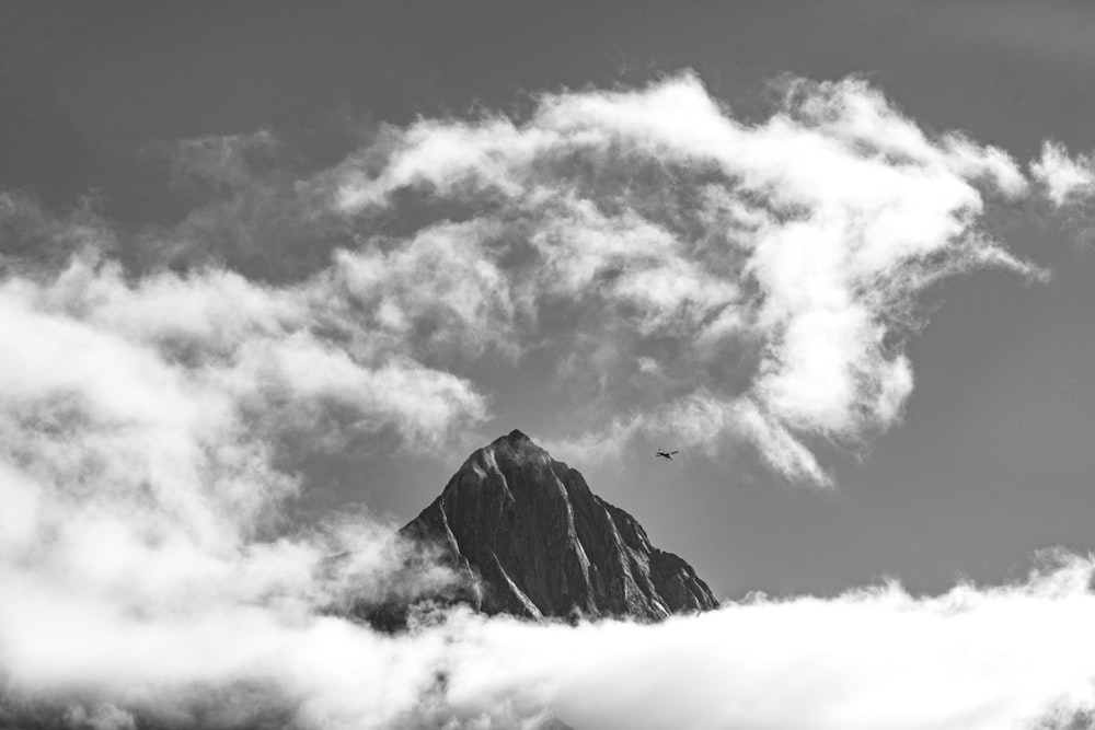 a black and white photo of a mountain in the clouds