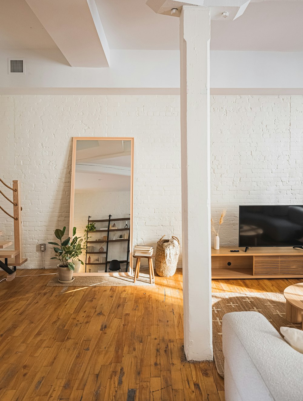 una sala de estar con suelos de madera y paredes blancas