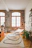 A couple relaxing in a stylish living room with modern decor and large windows.