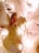 A handcrafted angel ornament with a heart design is placed on a brightly lit Christmas tree with white branches. The angel has a halo, painted features, and polka dot detailing.