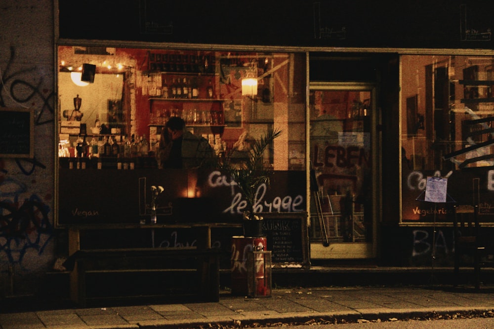 a store front with graffiti on it at night