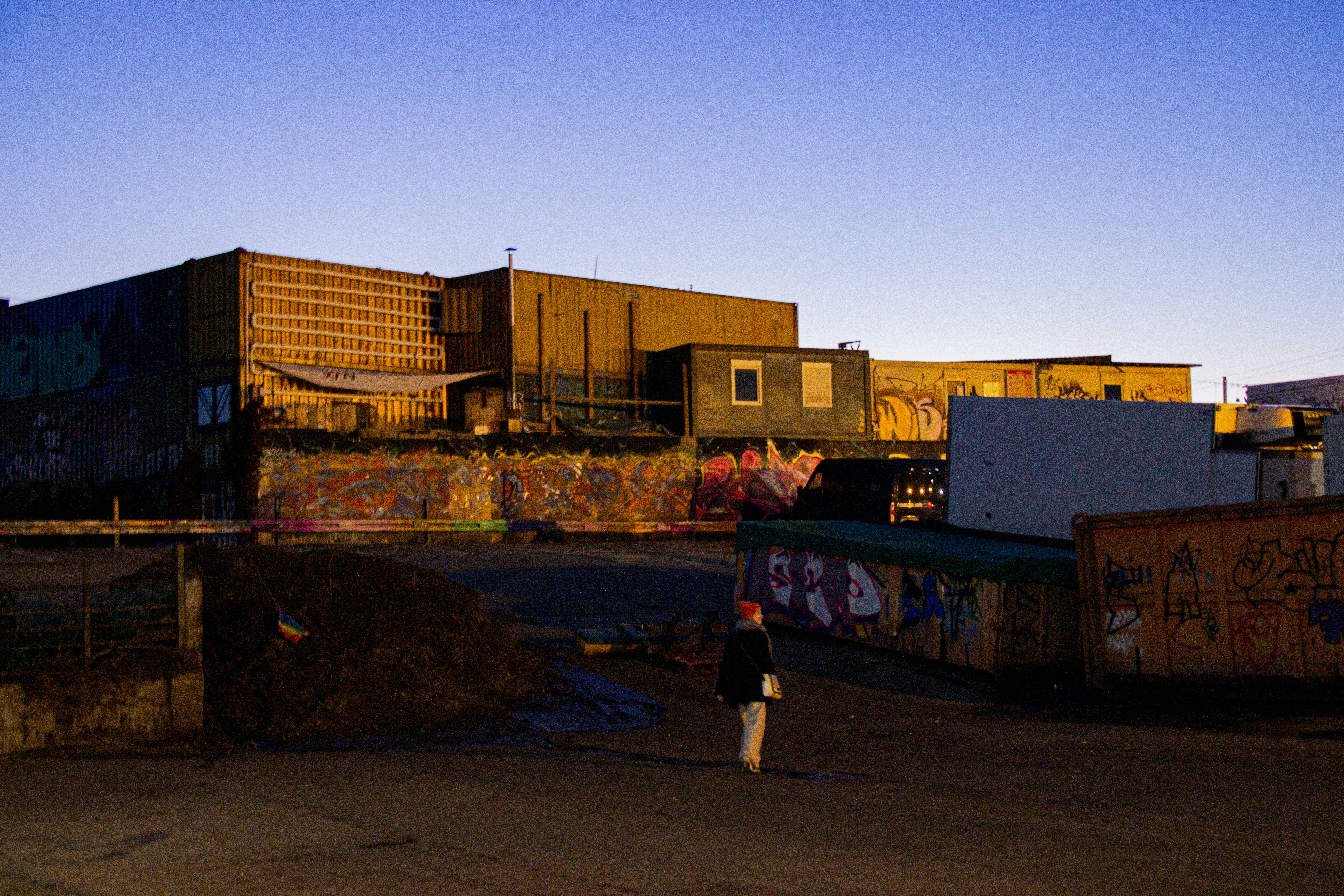 a person walking down a street in front of a building