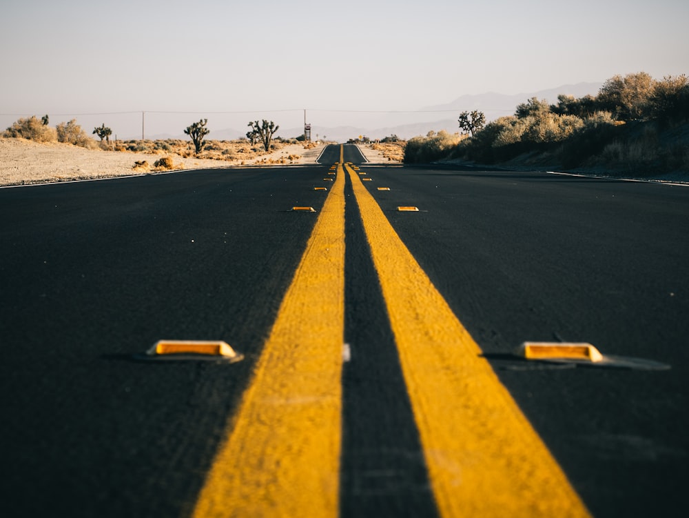 a yellow line on a road in the middle of the desert