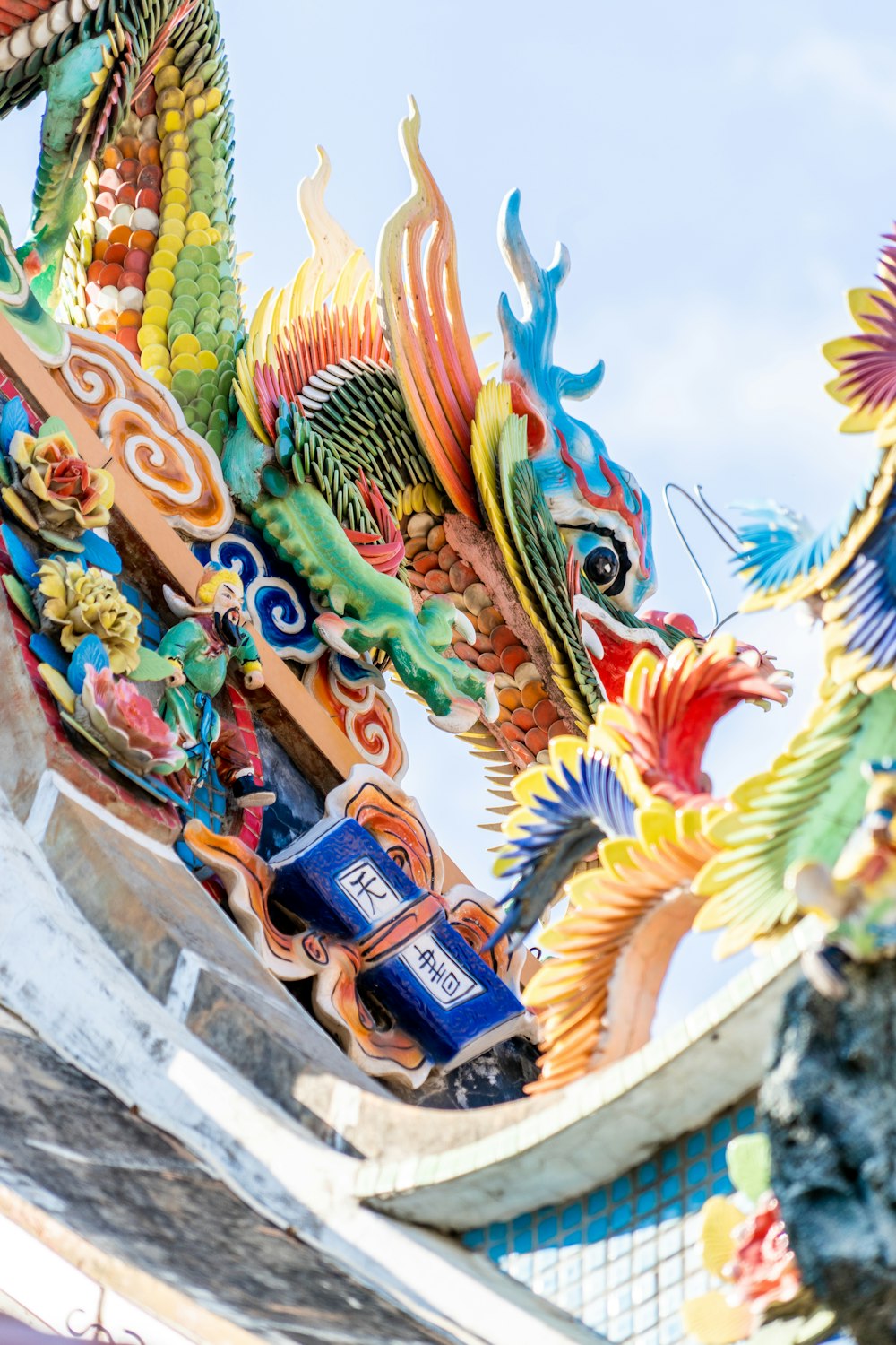 a colorful dragon sculpture on top of a building