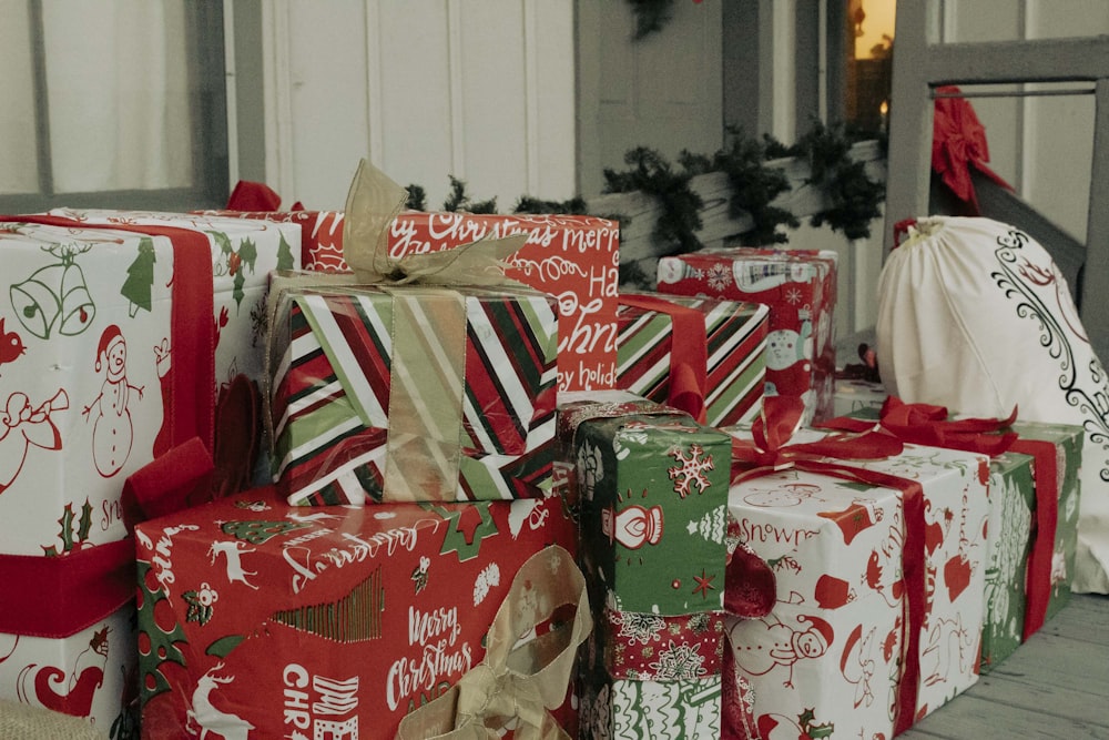 a pile of wrapped presents sitting on top of a wooden floor