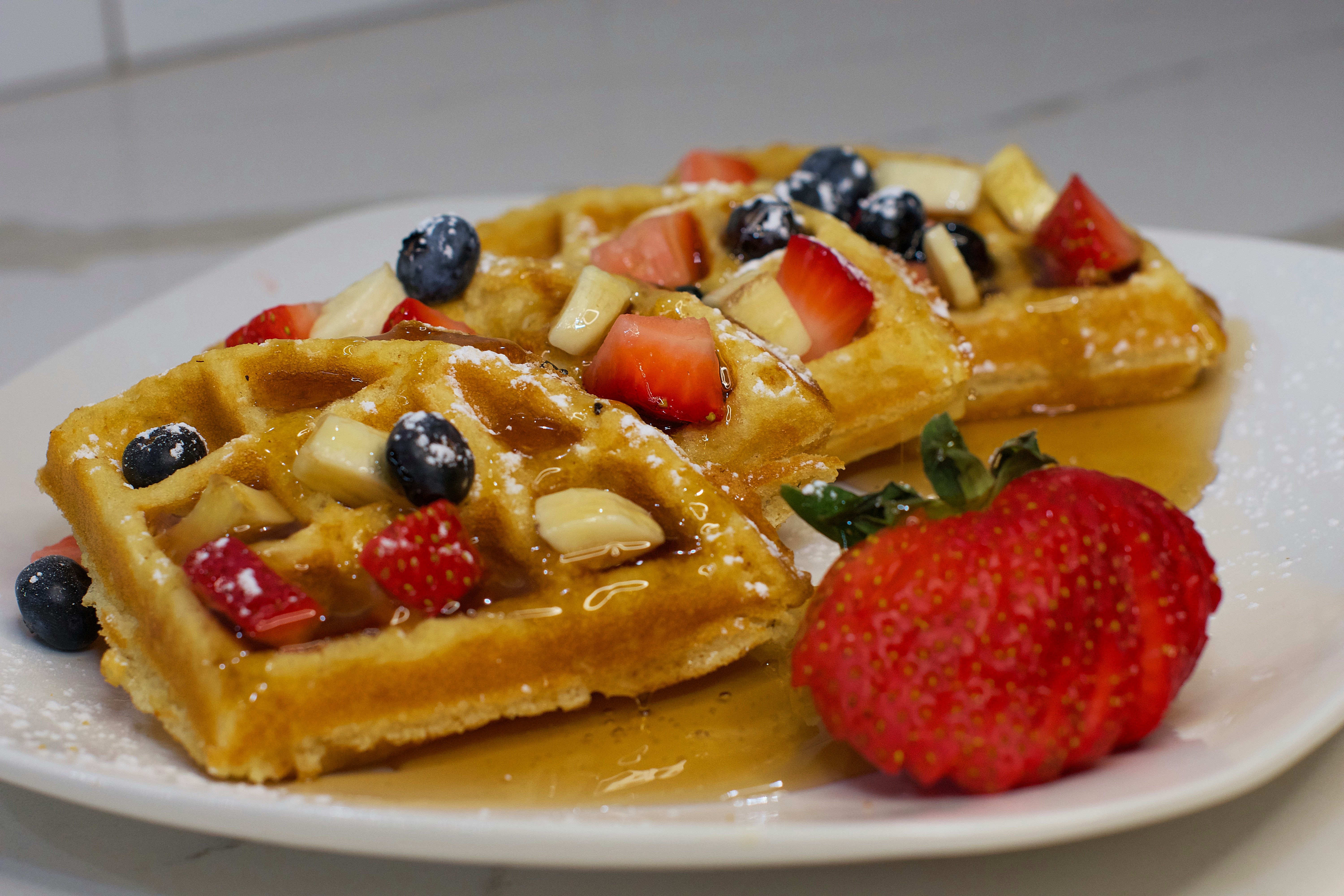 Waffle with fruit and syrup. 