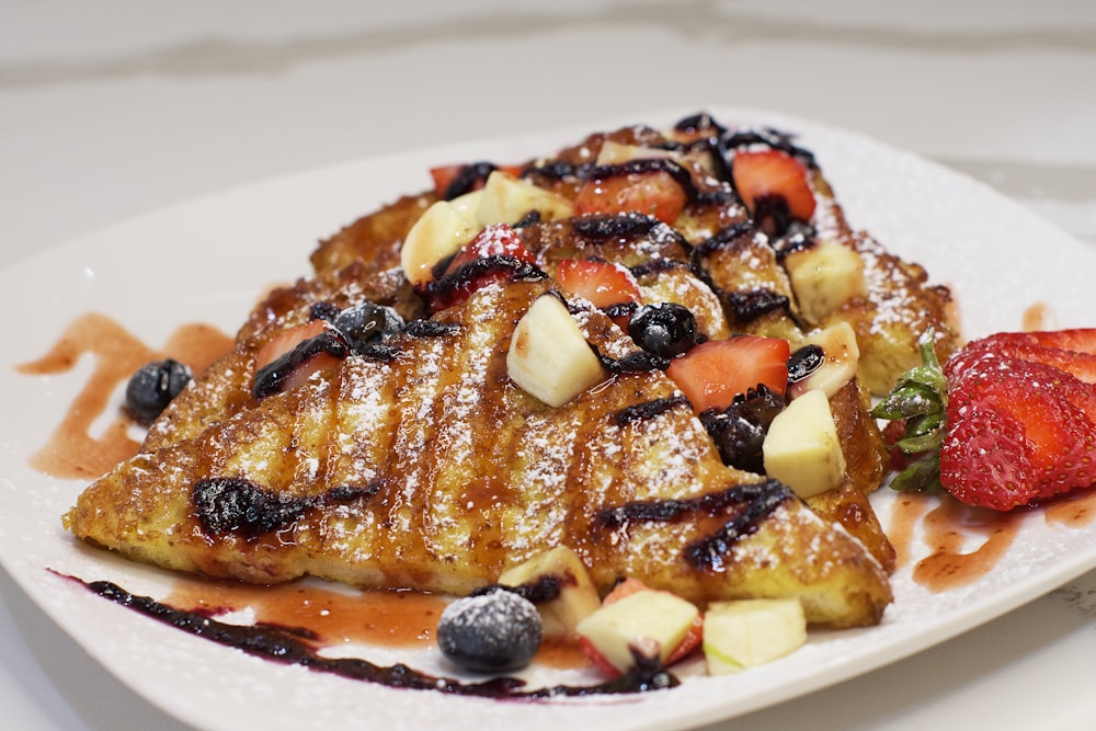 a white plate topped with french toast and fruit