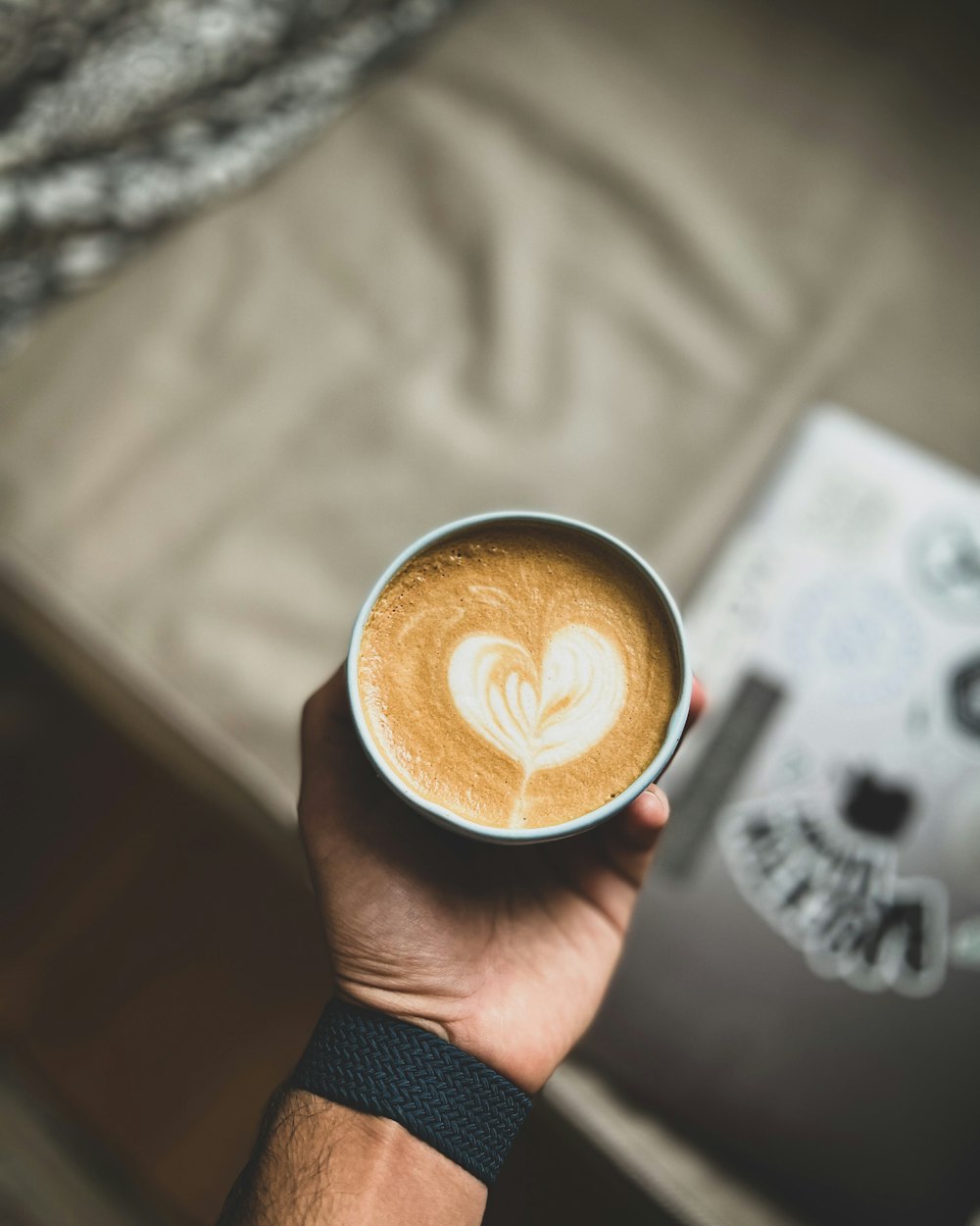 a person holding a cup of coffee in their hand