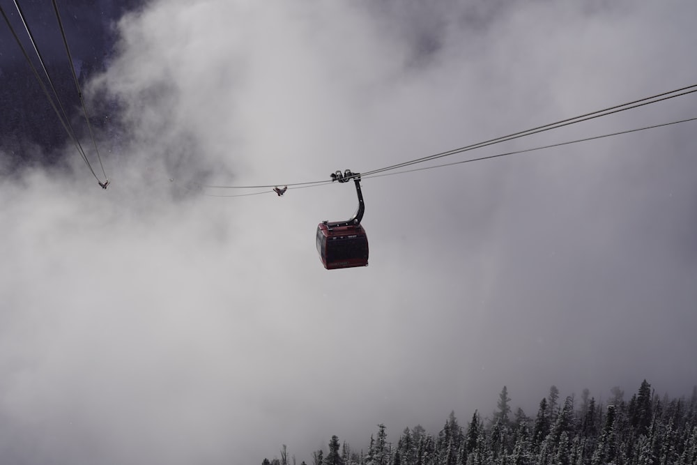 a ski lift going up a mountain in the clouds