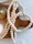 Beautifully wrapped crochet necklace presented in natural light on a wooden table.