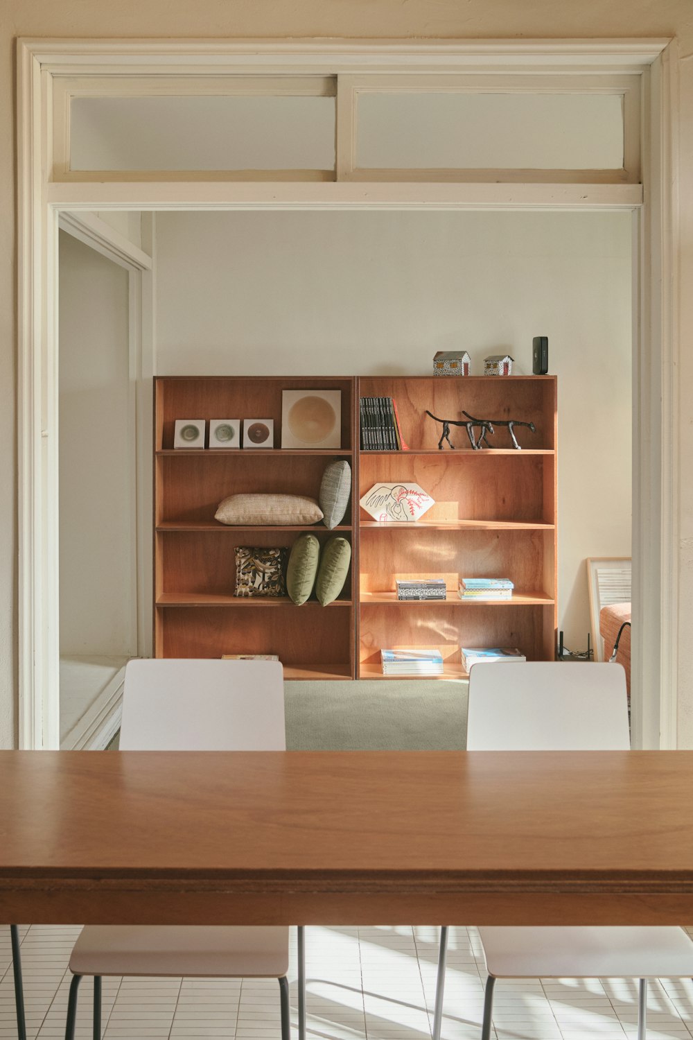 a wooden table sitting in front of a bookshelf