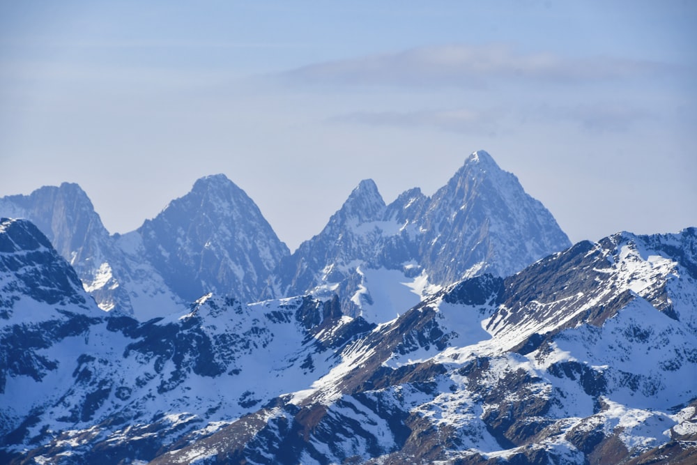 a group of mountains covered in snow under a blue sky