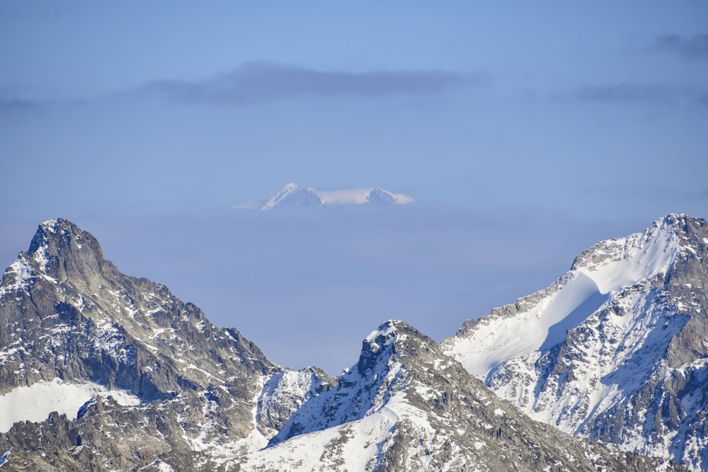 Un grupo de montañas cubiertas de nieve bajo un cielo azul