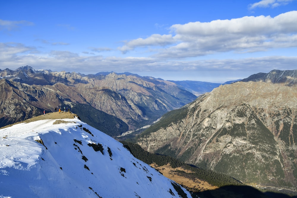 uma pessoa em pé no topo de uma montanha coberta de neve