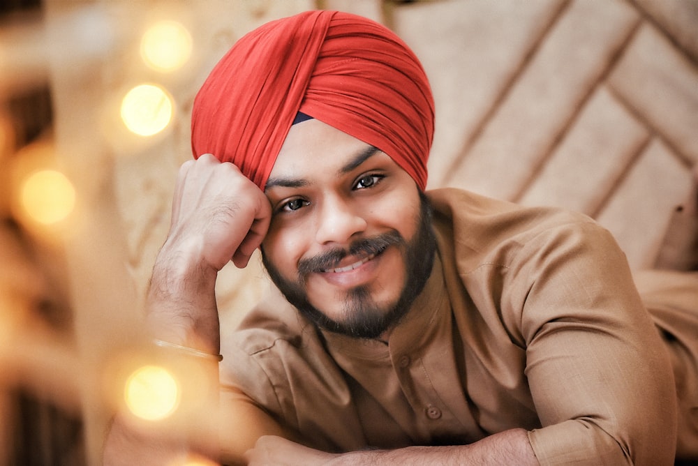 a man with a red turban is posing for a picture