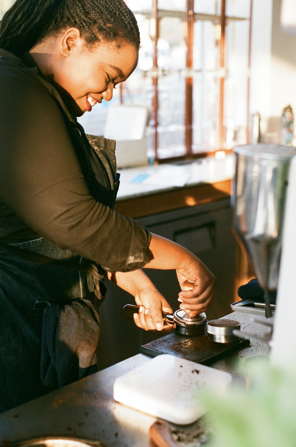 a woman is working on a stove in a kitchen