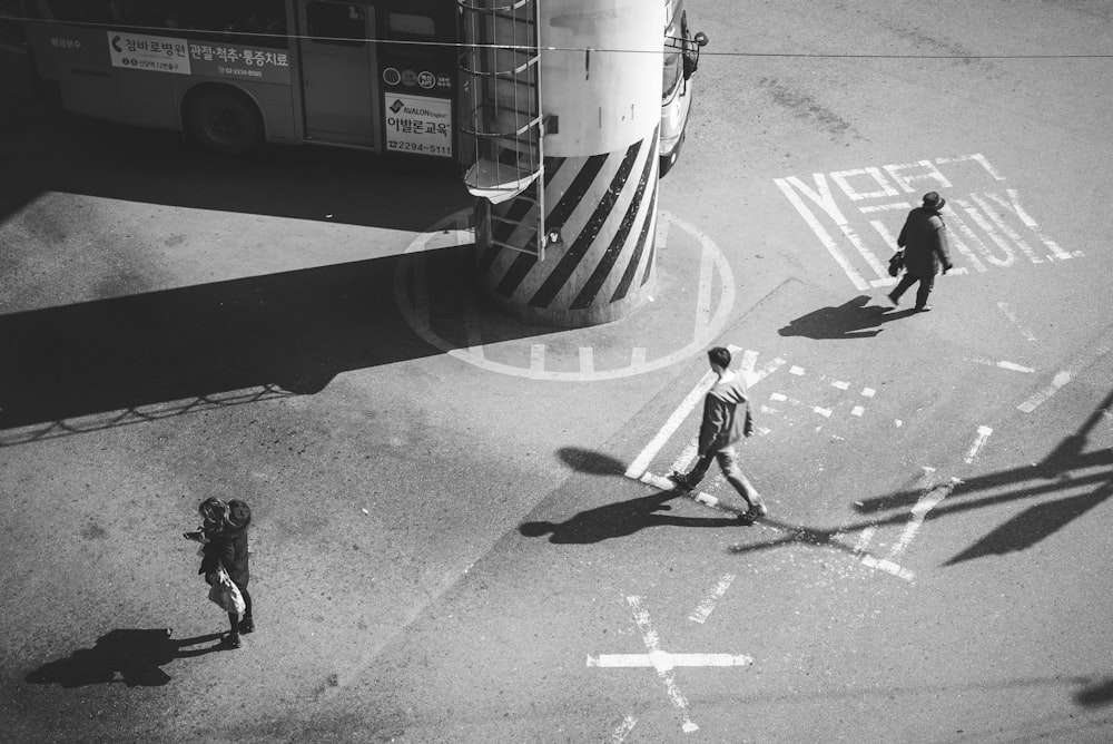 a black and white photo of people crossing the street