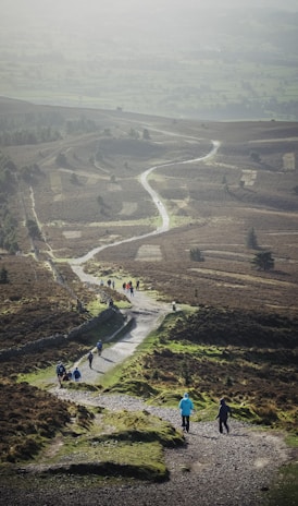 a group of people walking down a dirt road