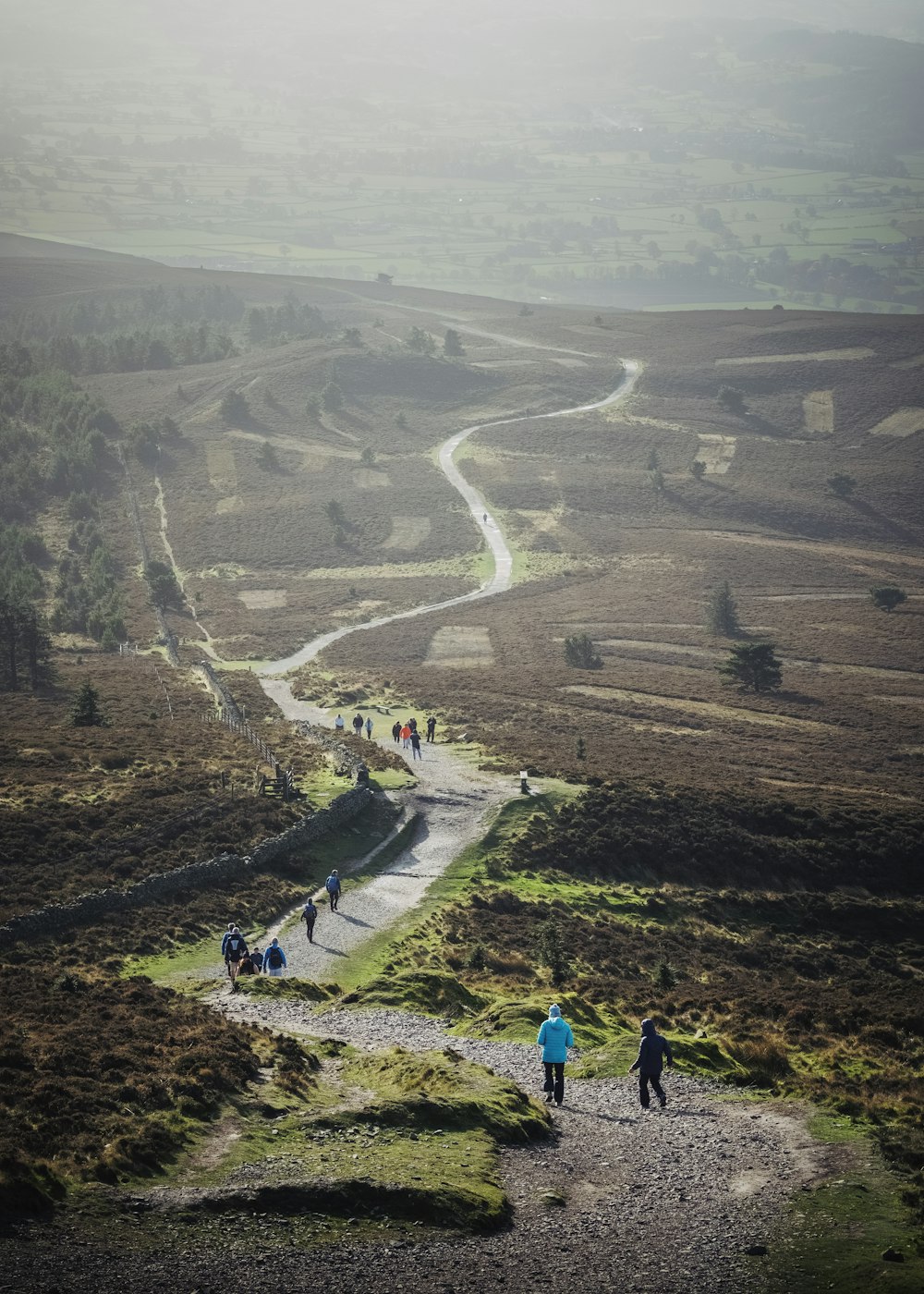 a group of people walking down a dirt road