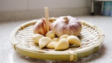 a basket of garlic and garlic bulbs on a counter