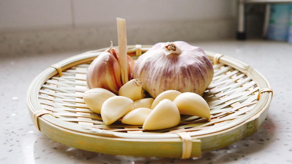 a basket of garlic and garlic bulbs on a counter