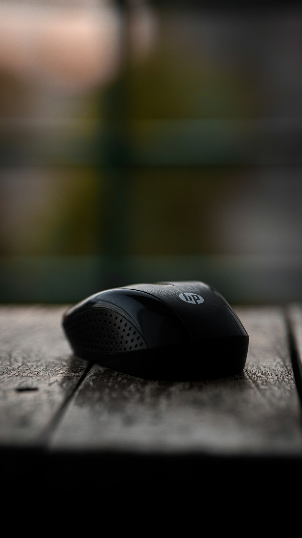 a black mouse sitting on top of a wooden table