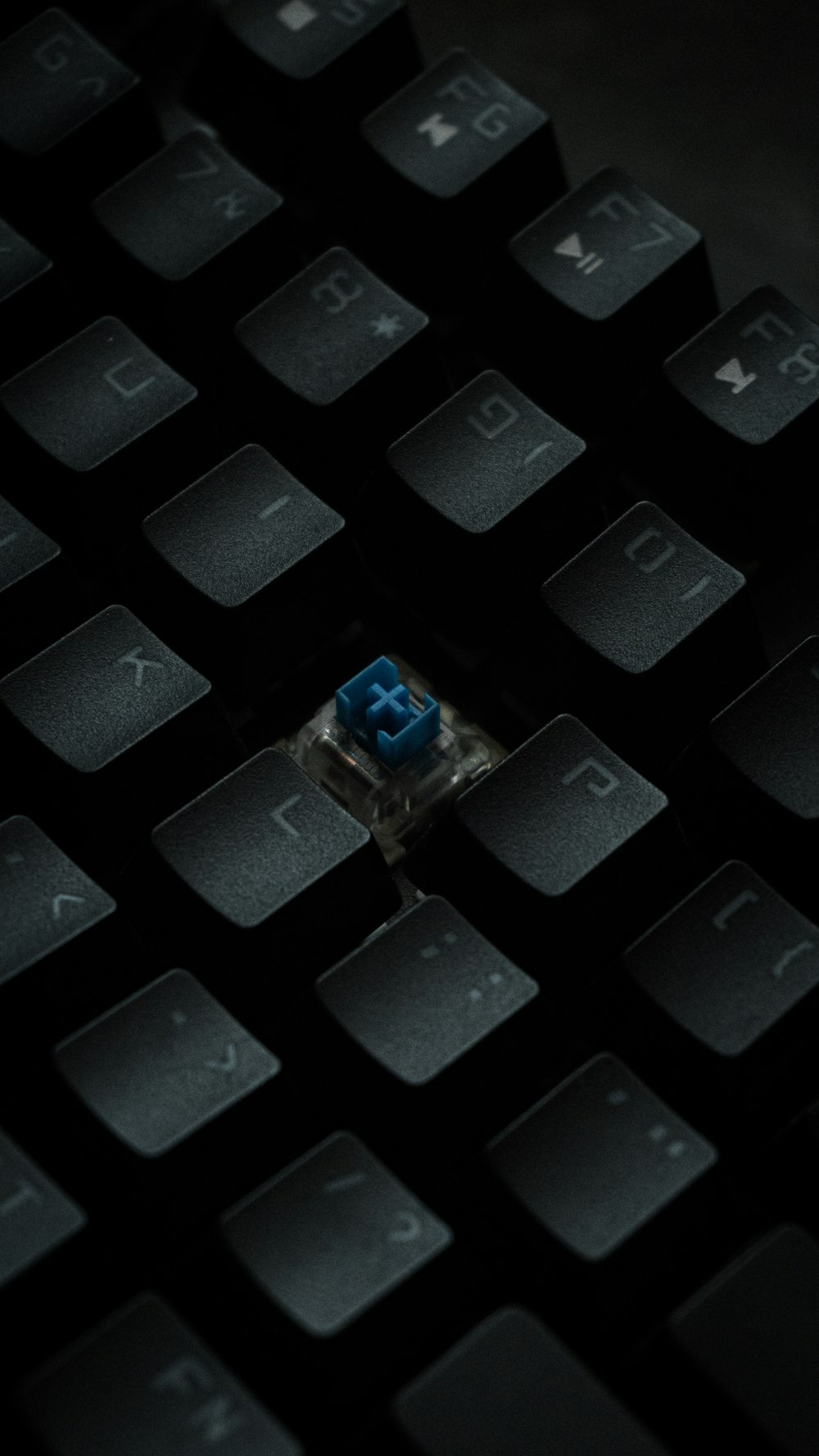 a close up of a computer keyboard with a blue button