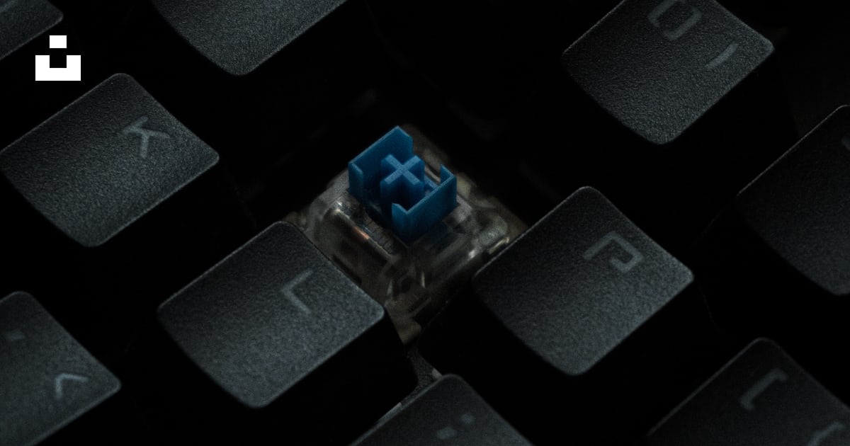 A close up of a computer keyboard with a blue button photo – Free ...