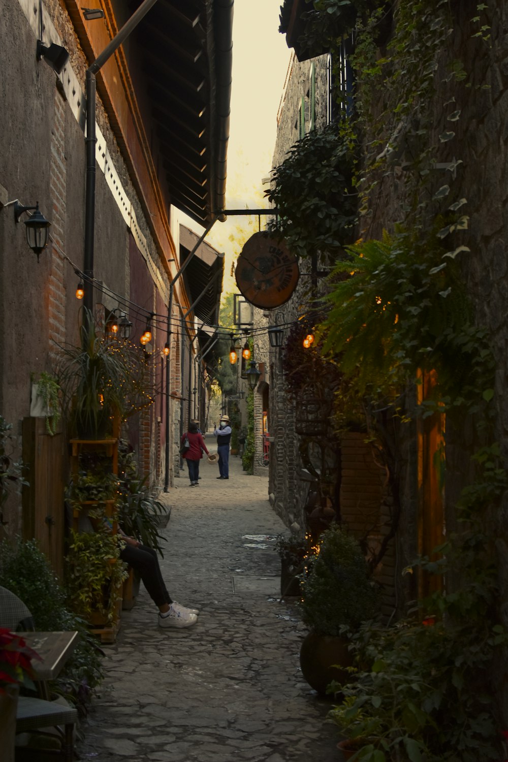 a narrow alley way with people walking down it