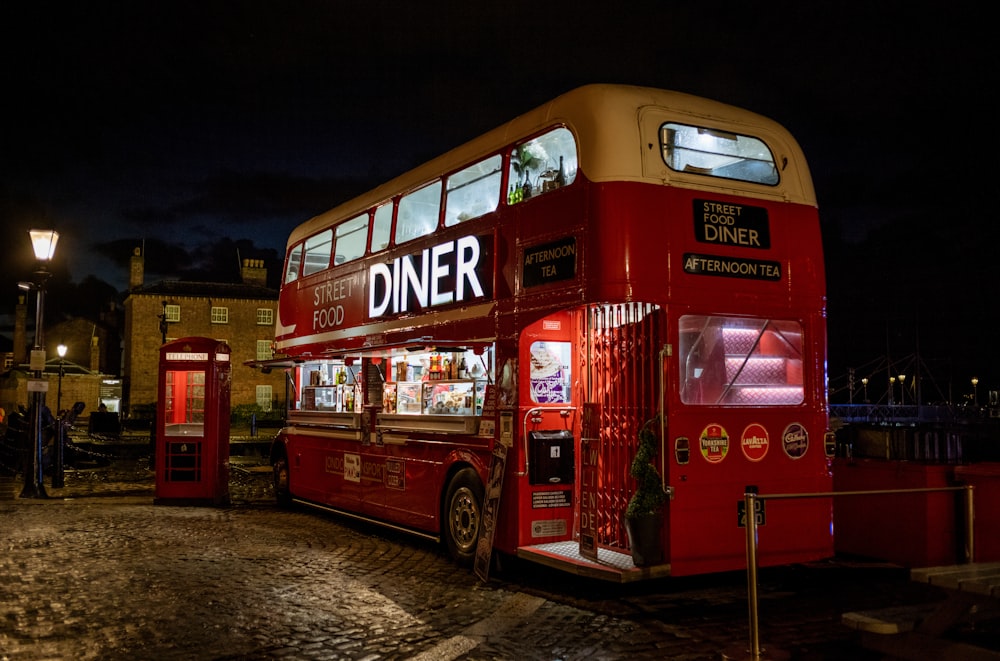 a red double decker bus parked in front of a building