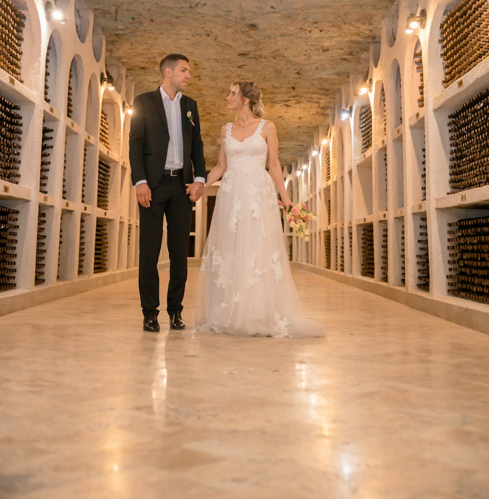 a bride and groom standing in a wine cellar