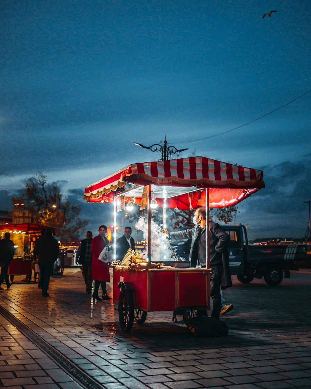 a red and white cart sitting on top of a sidewalk