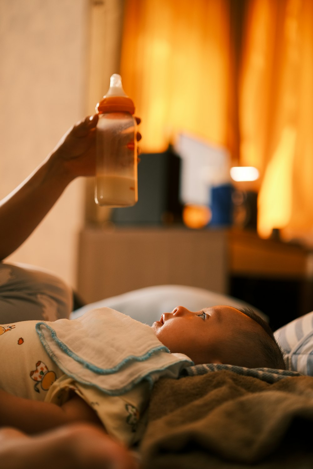 a woman feeding a baby a bottle of milk