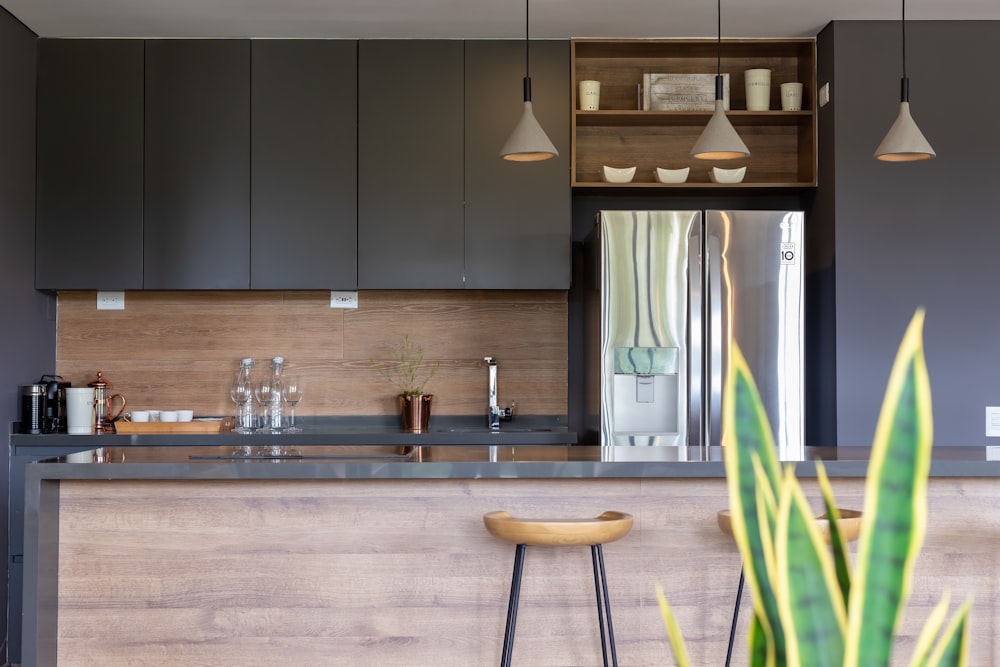 a modern kitchen with a bar and stools