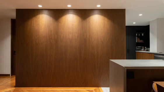 Warm and modern kitchen showroom featuring natural wood tones and cozy ambient lighting.