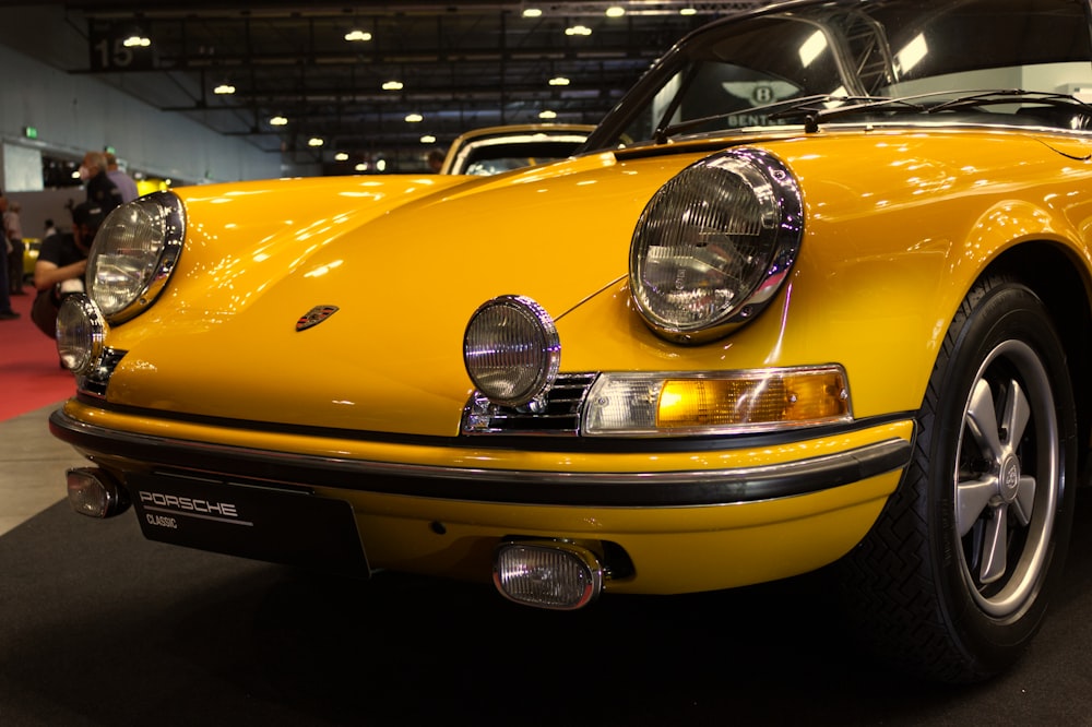 a yellow sports car is on display at a car show